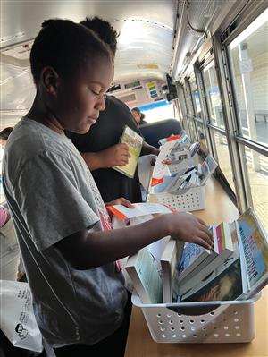 Students looking at books on the book bus